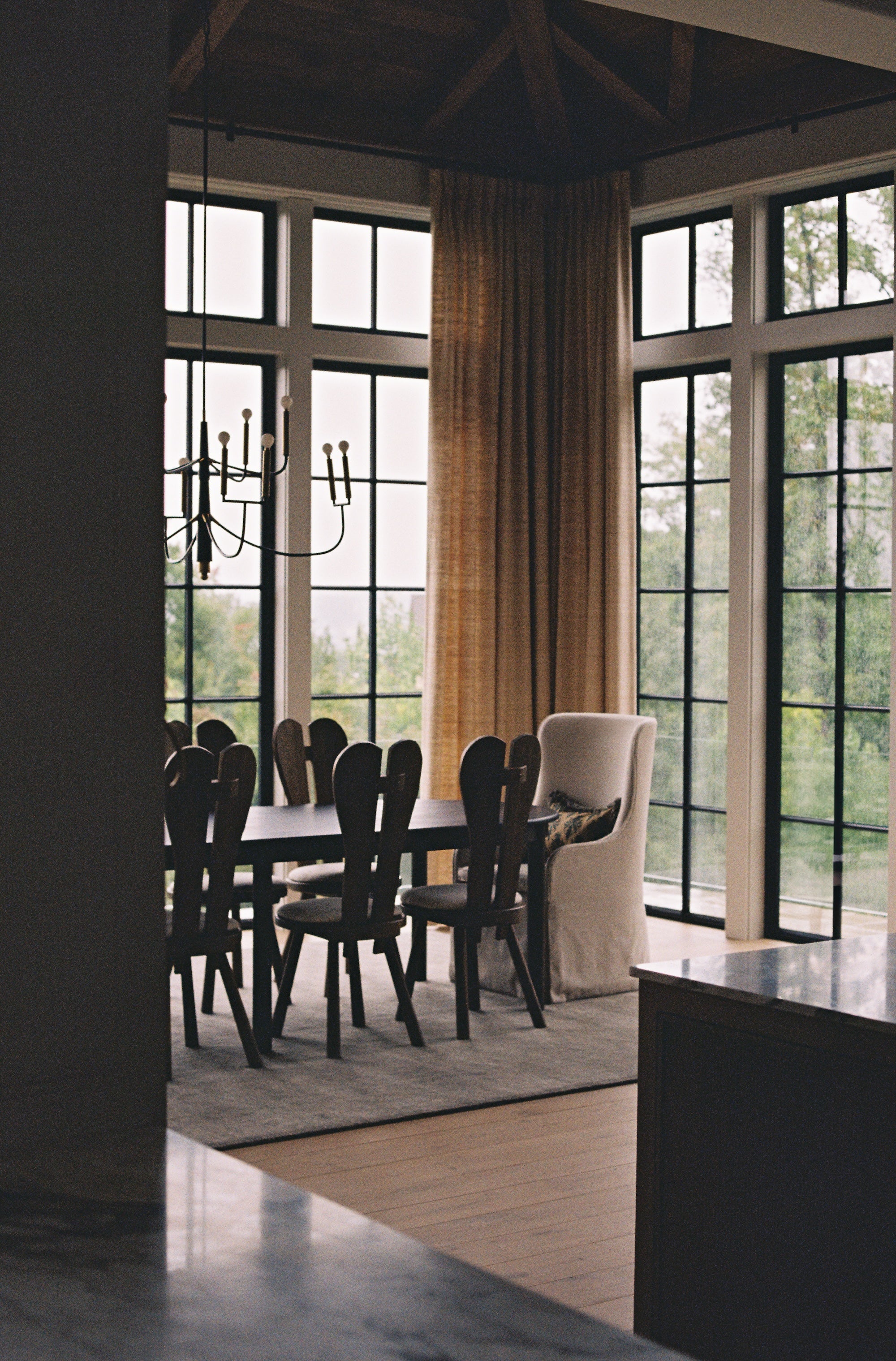 An image of a dining room with a wooden table, and wooden and upholstered chairs.