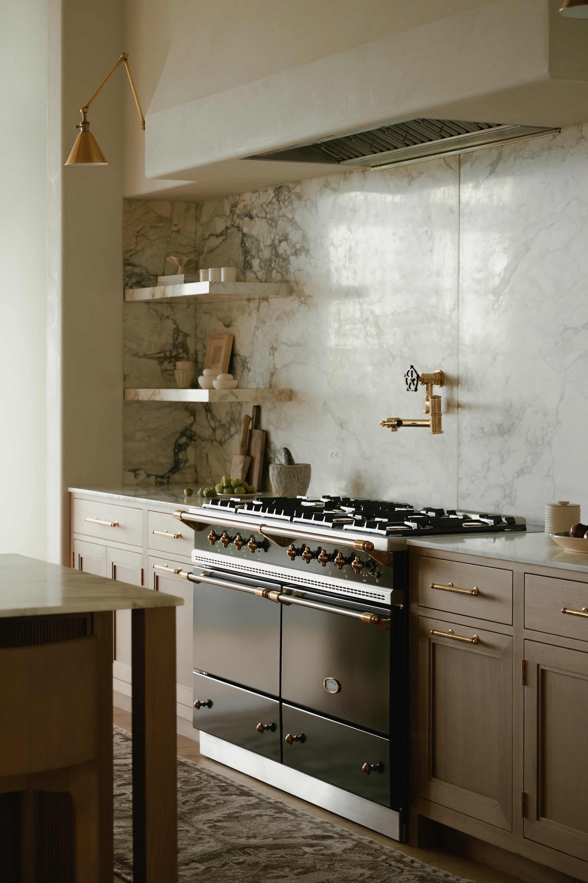 A kitchen with wooden cabinetry and a marble backsplash.