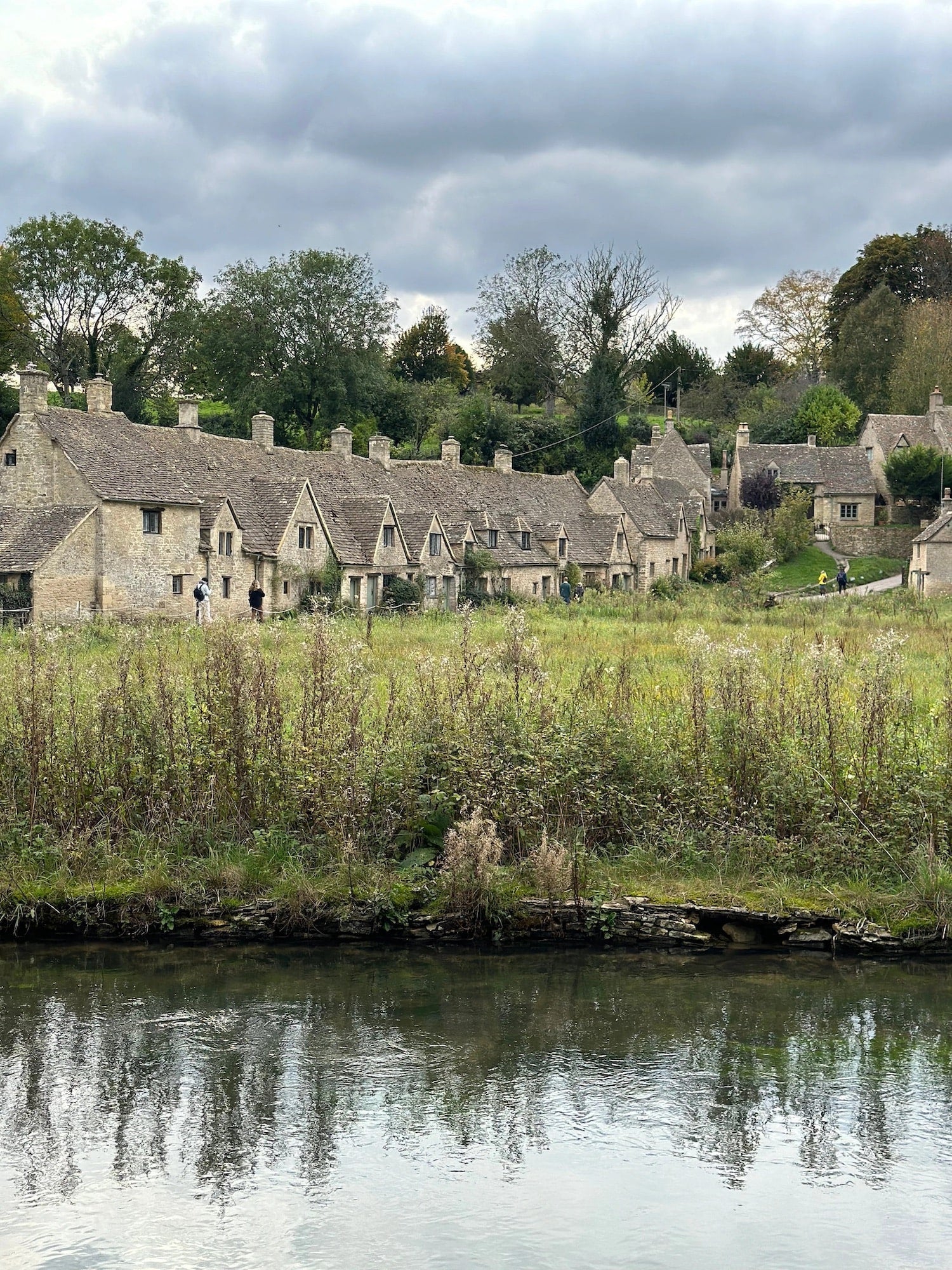 An image of homes behind a waterway in the Cotswolds.